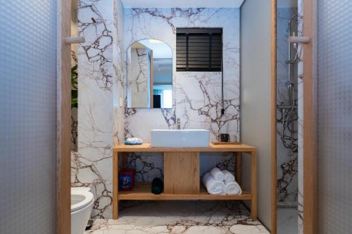 成都市にあるChengdu Kuanzhai Yuntu Serviced Apartmentの洗面台と鏡のあるバスルーム