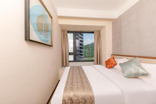 een slaapkamer met een groot bed met een raam bij Weili Royal Apartment in Maluan