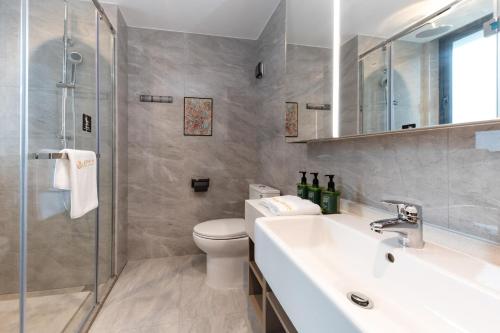 een badkamer met toilet, wastafel en douche bij Weili Royal Apartment in Maluan