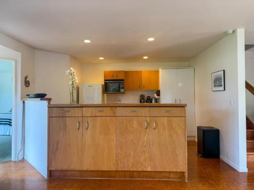 a kitchen with wooden cabinets and a white refrigerator at Tranquil Waterfront Getaway - Point Wells in Omaha
