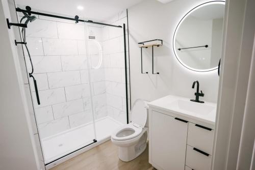 a bathroom with a shower and a toilet and a sink at Cozy & Stylish 1BR Suite in Regina