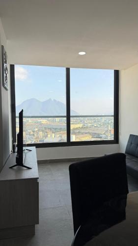 a living room with a couch and a desk with a computer at Ideal departamento en Catehua, Monterrey in Monterrey
