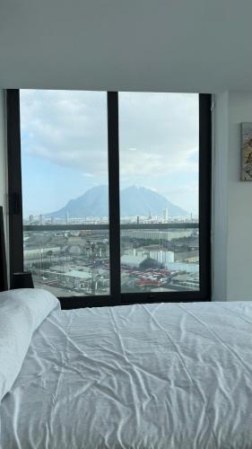a bedroom with a bed and a large window at Ideal departamento en Catehua, Monterrey in Monterrey