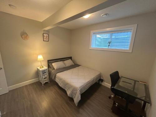 a small bedroom with a bed and a window at Cozy Family Friendly Suite Near Whyte, UofA, Kinsmen with Desks or Home-office and Full Kitchen in Edmonton