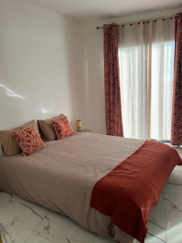 ein Schlafzimmer mit einem großen Bett mit roten Vorhängen in der Unterkunft Maison neuve, agréable avec vue mer et montagne in Saint-Pierre