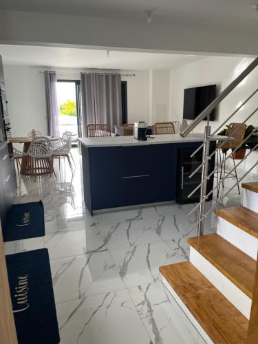 ein Wohnzimmer mit Marmorboden und einer Theke in der Unterkunft Maison neuve, agréable avec vue mer et montagne in Saint-Pierre