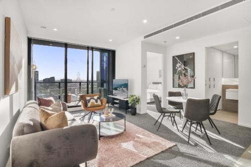 a living room with a couch and chairs and a table at Elegant 2-Bed with Superb Views & Amenities in Melbourne