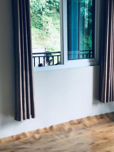 ein Fenster in einem Zimmer mit Blick auf einen Tisch in der Unterkunft Hidden leaf Guesthouse in Pokhara