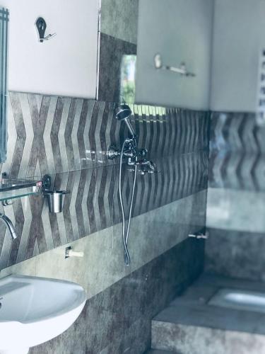 une salle de bain avec douche et lavabo dans l'établissement Hidden leaf Guesthouse, à Pokhara