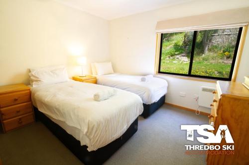 a hotel room with two beds and a window at Mowamba E6 in Thredbo