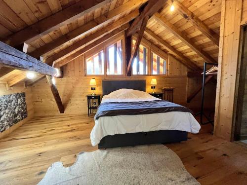 une chambre avec un lit dans une cabane en bois dans l'établissement Chalet rénové à Samoëns, proche centre, skis-bus - FR-1-624-186, à Samoëns
