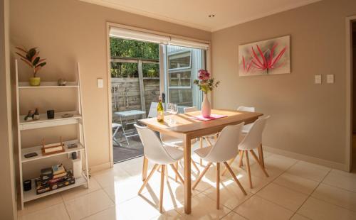a dining room with a table and white chairs at Great Location On Gilbert - 3BR 2 level townhouse in New Plymouth