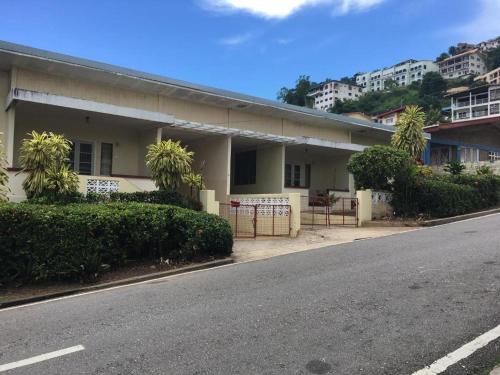 a building on the side of a street at Secure charming 1-bedroom house in Port-of-Spain