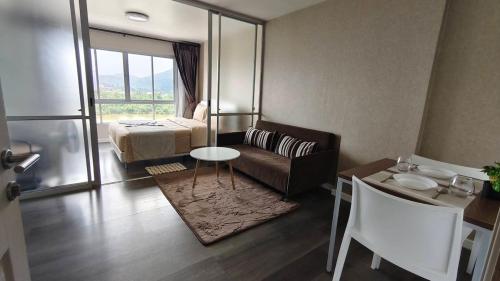 a living room with a couch and a bed and a table at The Azure Kathu in Kathu