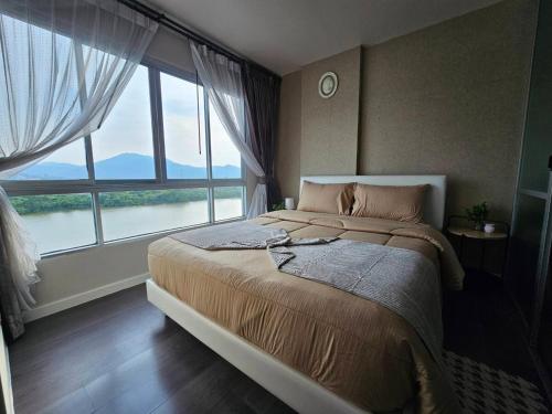 a bedroom with a large bed with a large window at The Azure Kathu in Kathu