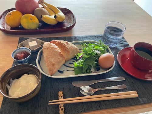 uma mesa com um prato de comida com pão e fruta em Oyashiki Stay Ko, お屋敷ステイ 幸 em Shodoshima