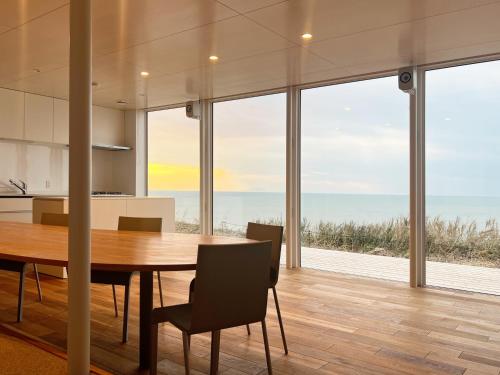 een keuken en eetkamer met een tafel en uitzicht op de oceaan bij Cliff House MORAI 2 