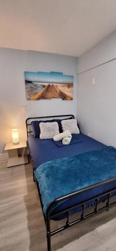 a bedroom with a blue bed with a painting on the wall at Blue Little Havana in Miami