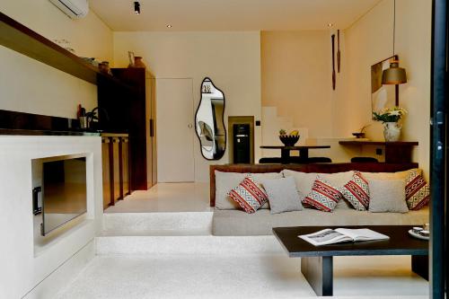 a living room with a couch and a fireplace at Yugen Villas in Uluwatu