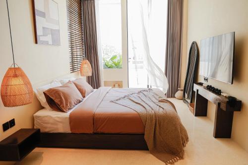 a bedroom with a bed and a large window at Yugen Villas in Uluwatu