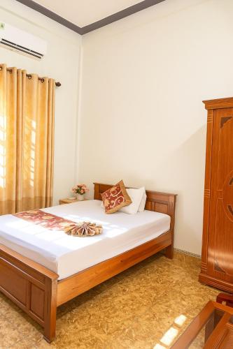 a bedroom with a bed and a wooden cabinet at Hồng Trà Hotel Quảng Ninh in Quang Ninh