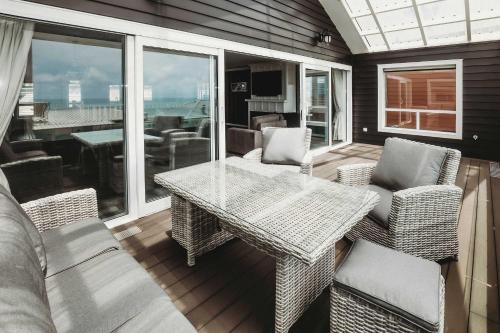 a screened in porch with a table and chairs at Buller Noire - luxury New Plymouth oceanview home in New Plymouth
