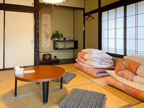 a room with a table and pillows on the floor at 松本はなれ Matsumoto HANARE - Japanese style private bedroom Guest hause in Matsumoto