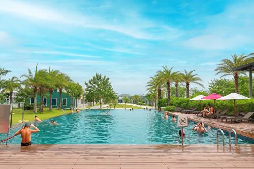 une grande piscine avec des gens dans l'eau dans l'établissement The Moon Villa - NOVAWORLD Phan Thiet, à Bình Tú