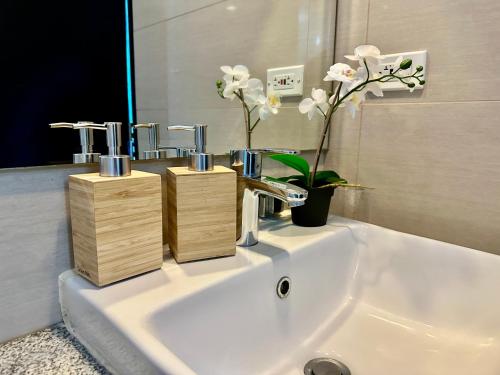 a bathroom sink with three faucets and a mirror at Modern Seaview 1BR Near Okada Manila Bay Airport 17 in Manila