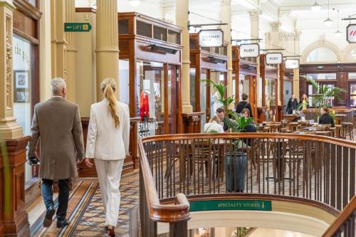 a man and woman walking through a shopping mall at Quest Wellington in Wellington