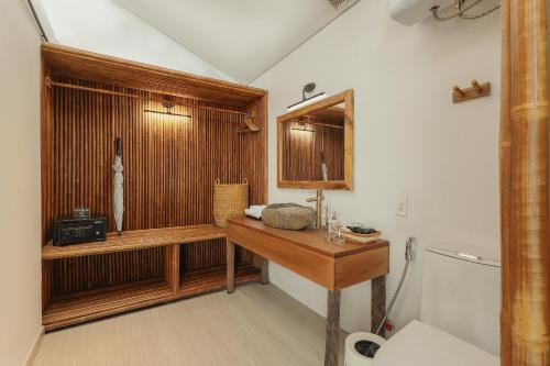 a bathroom with a wooden sink and a toilet at M Village Phu Quoc in Phú Quốc