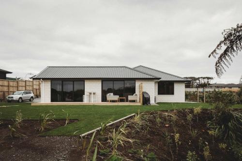 a house with a black roof and large windows at Bell Block Beauty - pristine 3BR home near beach in New Plymouth
