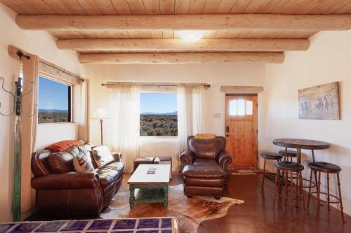 - un salon avec un fauteuil et une table dans l'établissement Casa de Alfarero - Hot Tub - EV Charger - Gas Grill - Mountain Views, à Arroyo Hondo