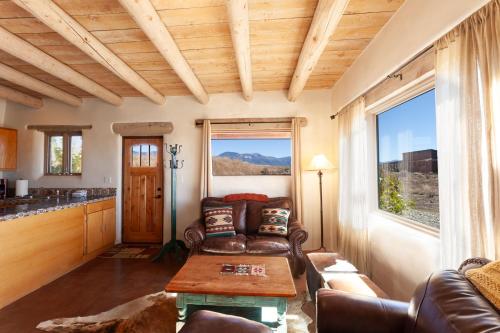 un salon avec un canapé et une table dans l'établissement Casa de Alfarero - Hot Tub - EV Charger - Gas Grill - Mountain Views, à Arroyo Hondo