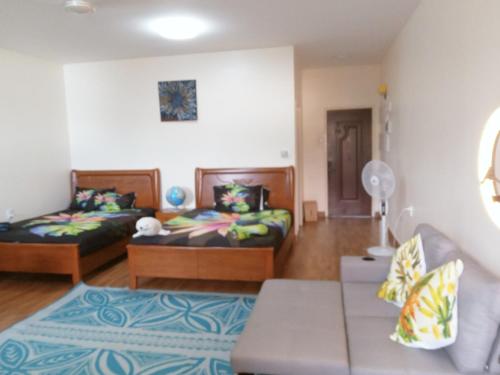 VaiteleにあるSamoa FINAU 685 Accomodationsのベッド2台とソファのあるリビングルーム