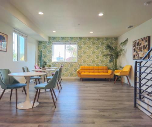 ein Wartezimmer mit einer gelben Couch und Tischen und Stühlen in der Unterkunft Forty First Place - Boutique Hostel in Los Angeles