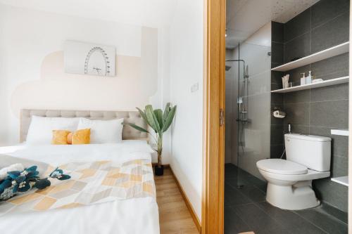 a bedroom with a white bed and a toilet at Label6 Studio West Lake in Hanoi