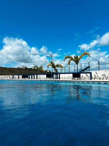 Apartamento luxo e novo com vista em Gravatá في غرافاتا: مسبح بالماء الأزرق والنخيل