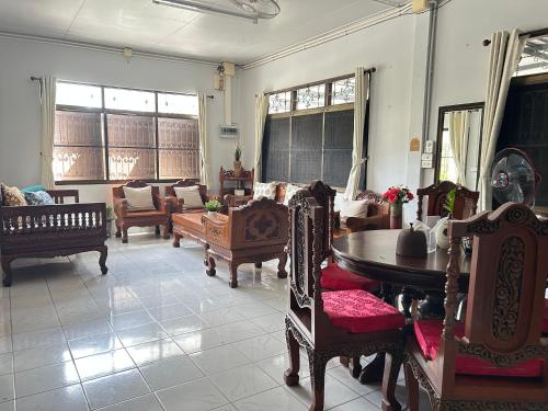ein Wohnzimmer mit Stühlen und einem Tisch in der Unterkunft Wooden Friend House in Krabi