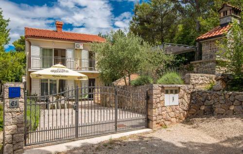 a gate in front of a house with a stone fence at Apartments in Soline - Insel Krk 41809 in Soline