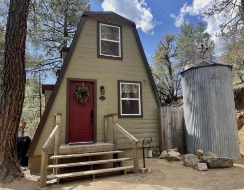 a tiny house with a red door and a tree at Cozy Rustic Cabin in the Prescott National Forest near Lynx Lake in Prescott, Arizona in Walker