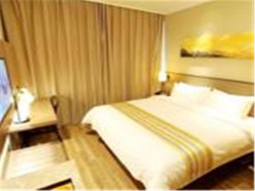 a hotel room with a bed and a television at Home Inn Ji'nan Dikou Road Railway Station North Square in Jinan