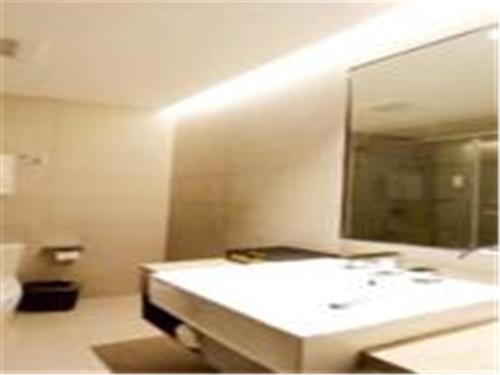 bagno con lavandino bianco e specchio di Home Inn Ji'nan Dikou Road Railway Station North Square a Jinan
