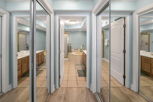 a bathroom with two sinks and two mirrors at Sandpiper 304 in Tybee Island