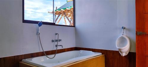 a bathroom with a urinal and a bath tub at Los uros Domo Atardecer in Puno