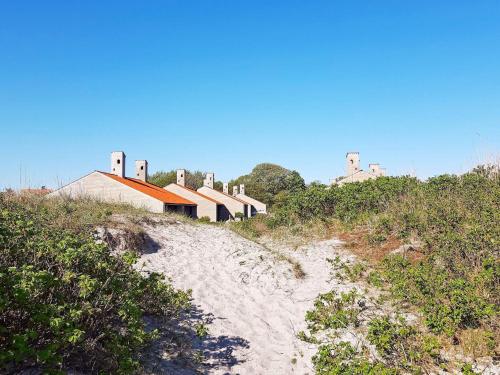 a house on a hill with a sandy path to a beach at 6 person holiday home on a holiday park in Sæby in Sæby