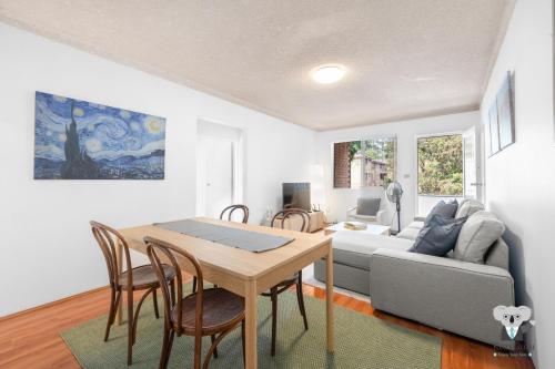 a living room with a table and a couch at KozyGuru | Westmead | 2Bed Unit + Free Parking in Sydney