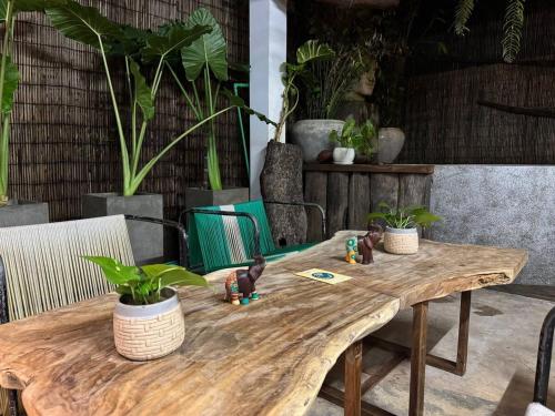 a wooden table with plants on top of it at Gallery House - Artistic Villa with Plunge Pool in Phumĭ Réach Born (1)
