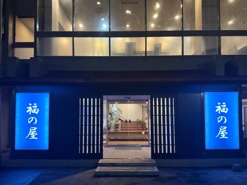 a building with blue signs on the front of it at 源泉の湯 福の屋 in Minakami