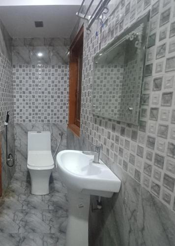 a bathroom with a sink and a toilet at Hotel Shimla Inn in Lucknow